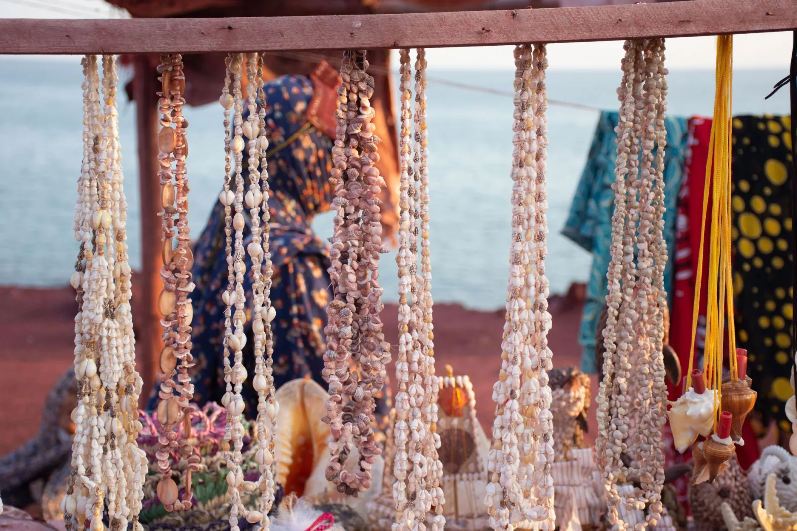 Shell jewelry on display at a vibrant market stall by the seaside in Hormoz, Iran.