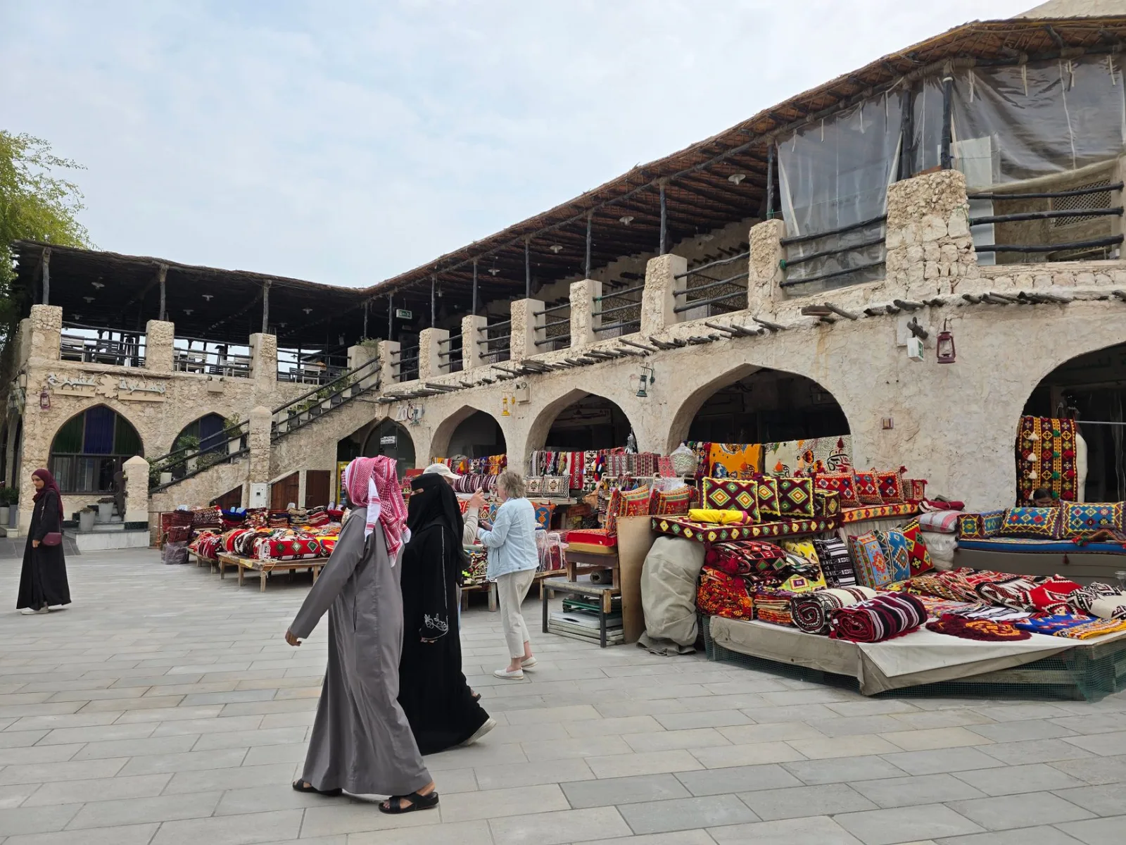 Bustling outdoor souk in the UAE showcasing vibrant textiles and traditional architecture.