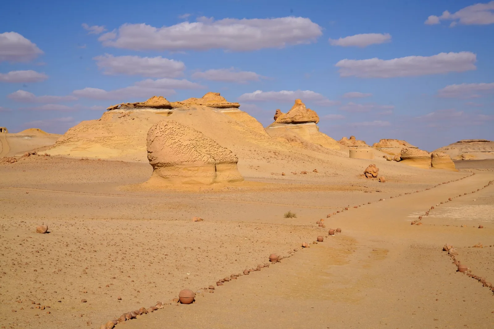 Stunning desert landscape of Wadi Al-Hitan in Egypt with unique rock formations under a bright sky.