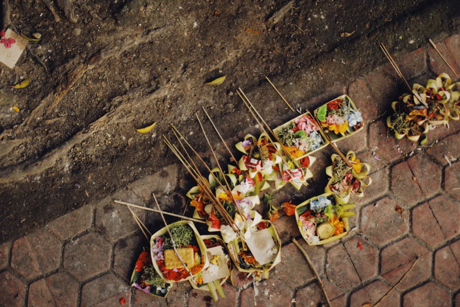 Colorful Balinese offerings on street pavement, symbolizing local traditions.