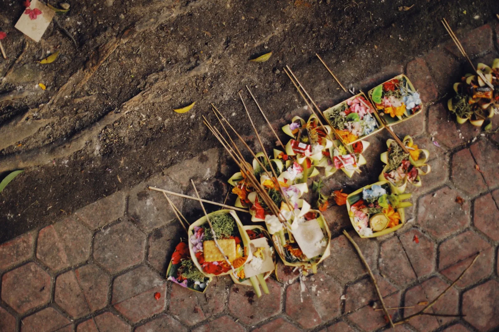 Traditional Balinese offerings on a stone street, vibrant and colorful, showcasing cultural ritual.