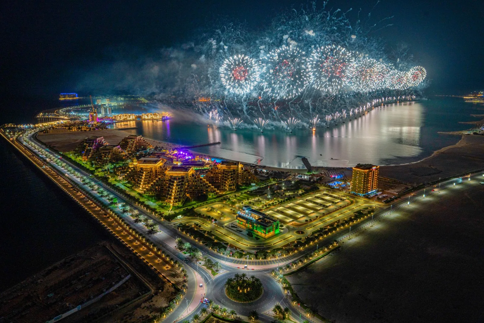 Dazzling fireworks illuminate Ras al Khaimah's harbor, captured in a stunning aerial night view.