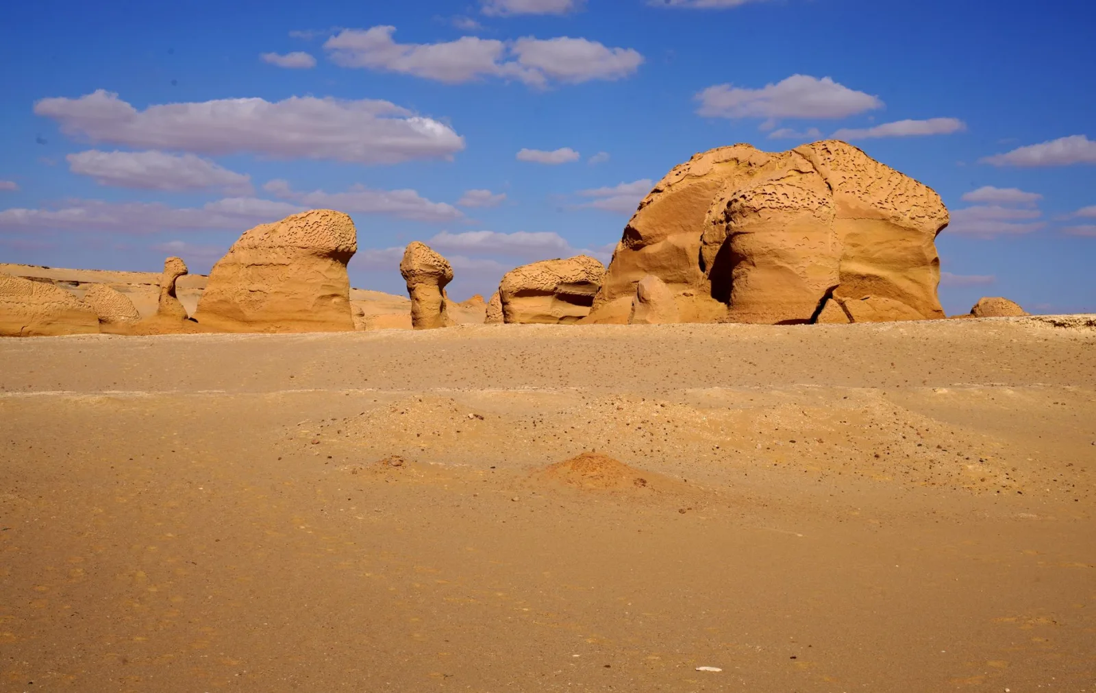 Capture of mysterious rock formations against a bright blue sky in Egypt's desert landscape.