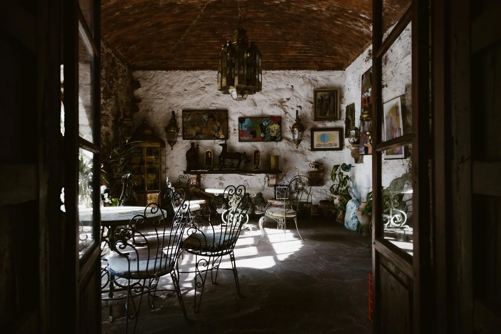 Explore this rustic interior highlighting vintage style with wrought iron furniture and eclectic decorations.