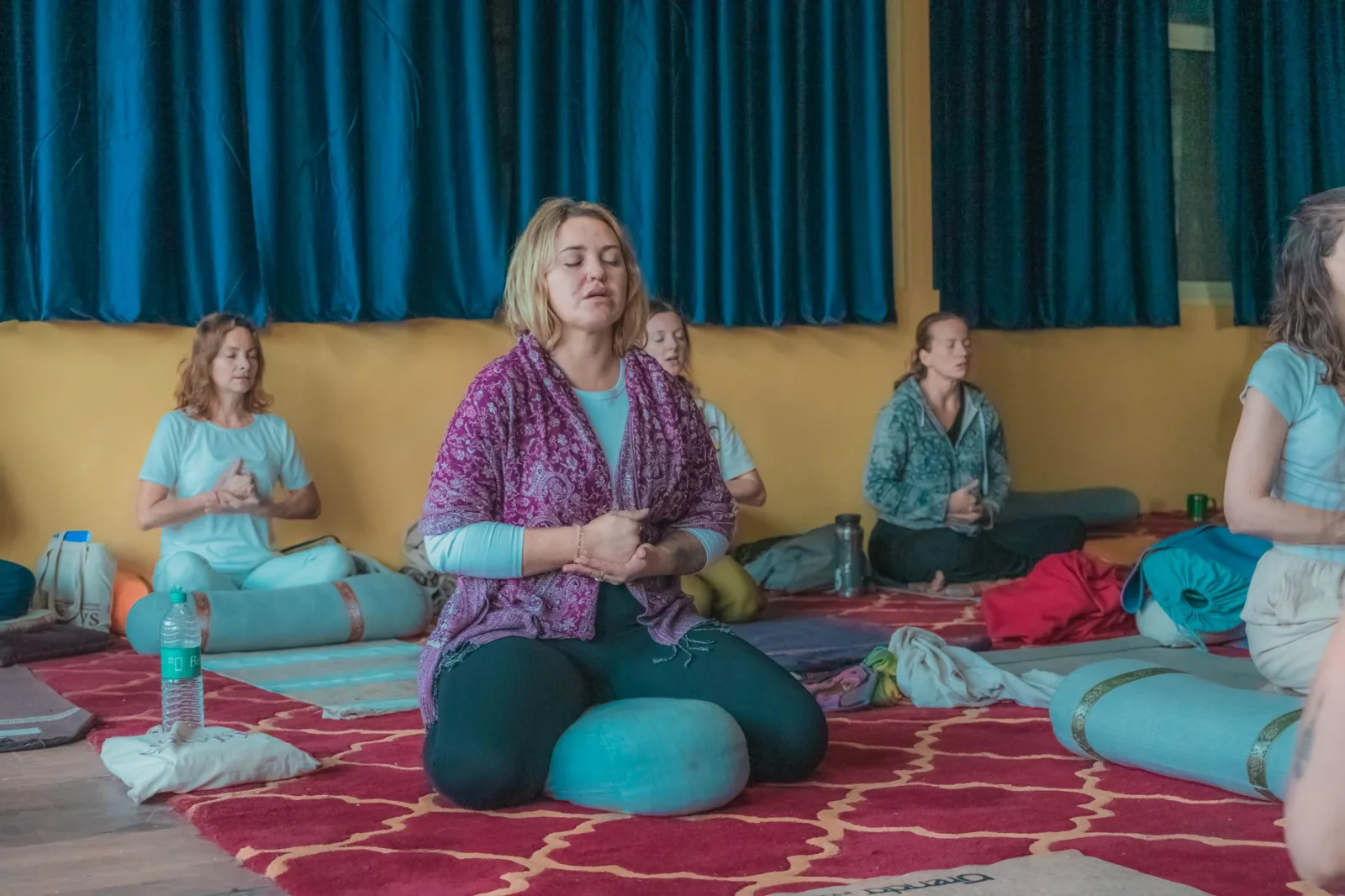 Women practicing meditation and mindfulness in a yoga class in Rishikesh, India.