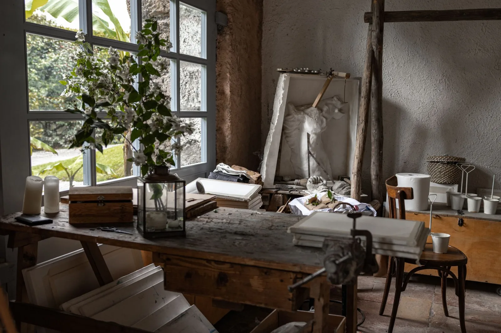 Beautiful rustic studio with vintage decor, wooden furniture, and natural light streaming through large windows.
