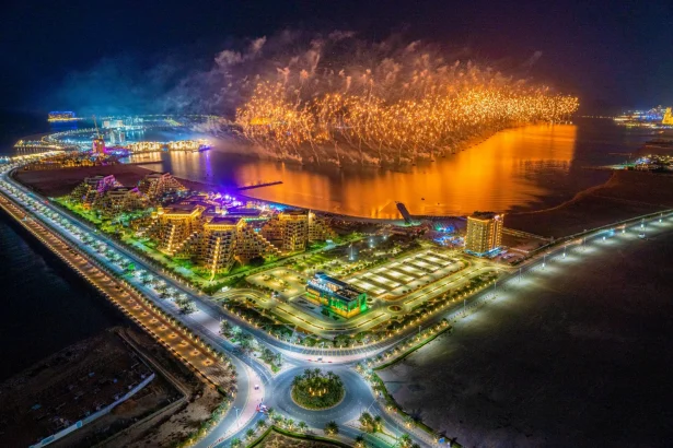 A breathtaking aerial view of fireworks illuminating Ras al Khaimah during a nighttime celebration.