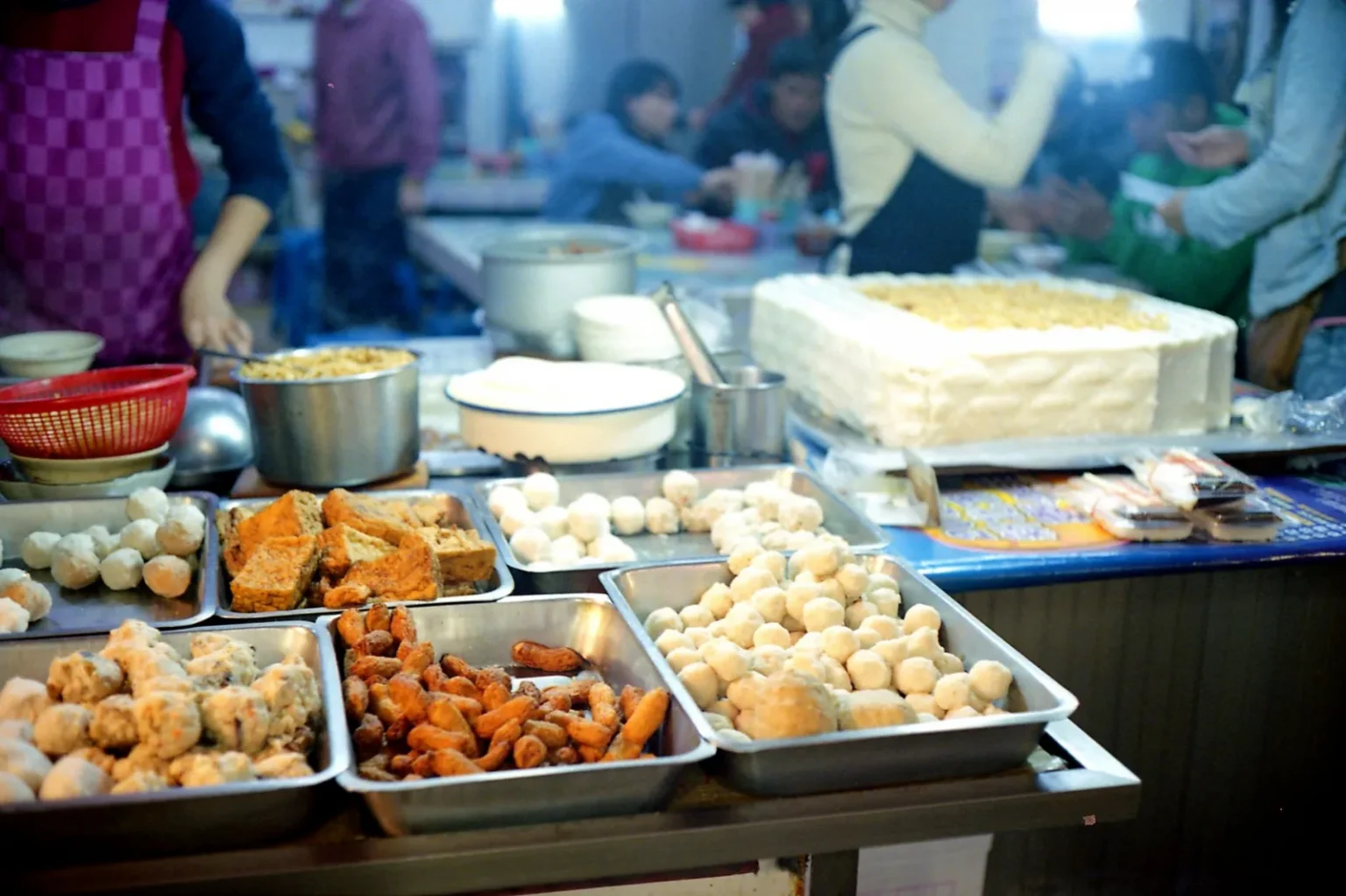 A bustling night market scene in New Taipei City featuring diverse street foods and lively atmosphere.
