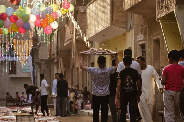 Vibrant street festival with balloons and people celebrating in traditional attire.