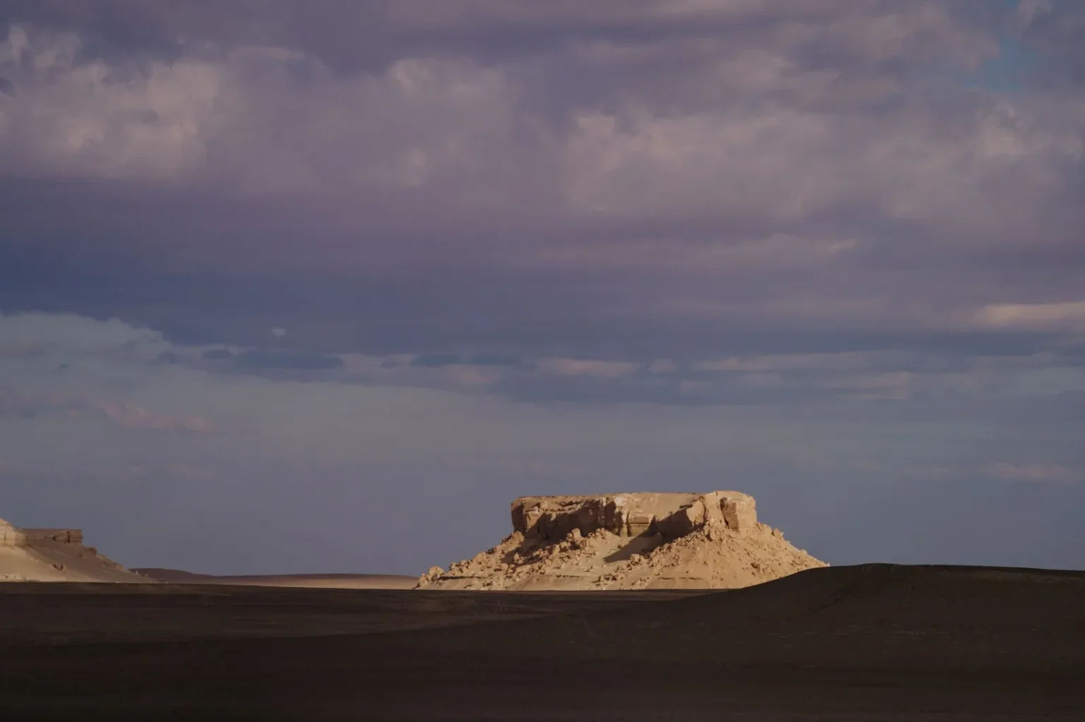Explore the captivating rock formations of Faiyum, Egypt at sunset, showcasing natural desert beauty.