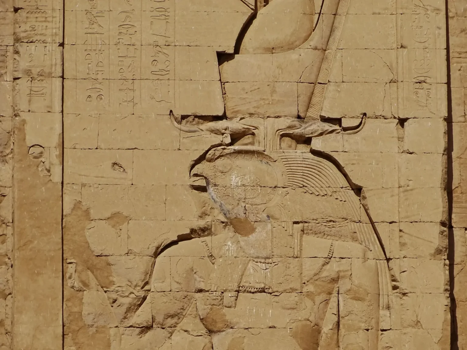Intricate relief depicting Egyptian deity, showcasing ancient art in Edfu Temple, Aswan.