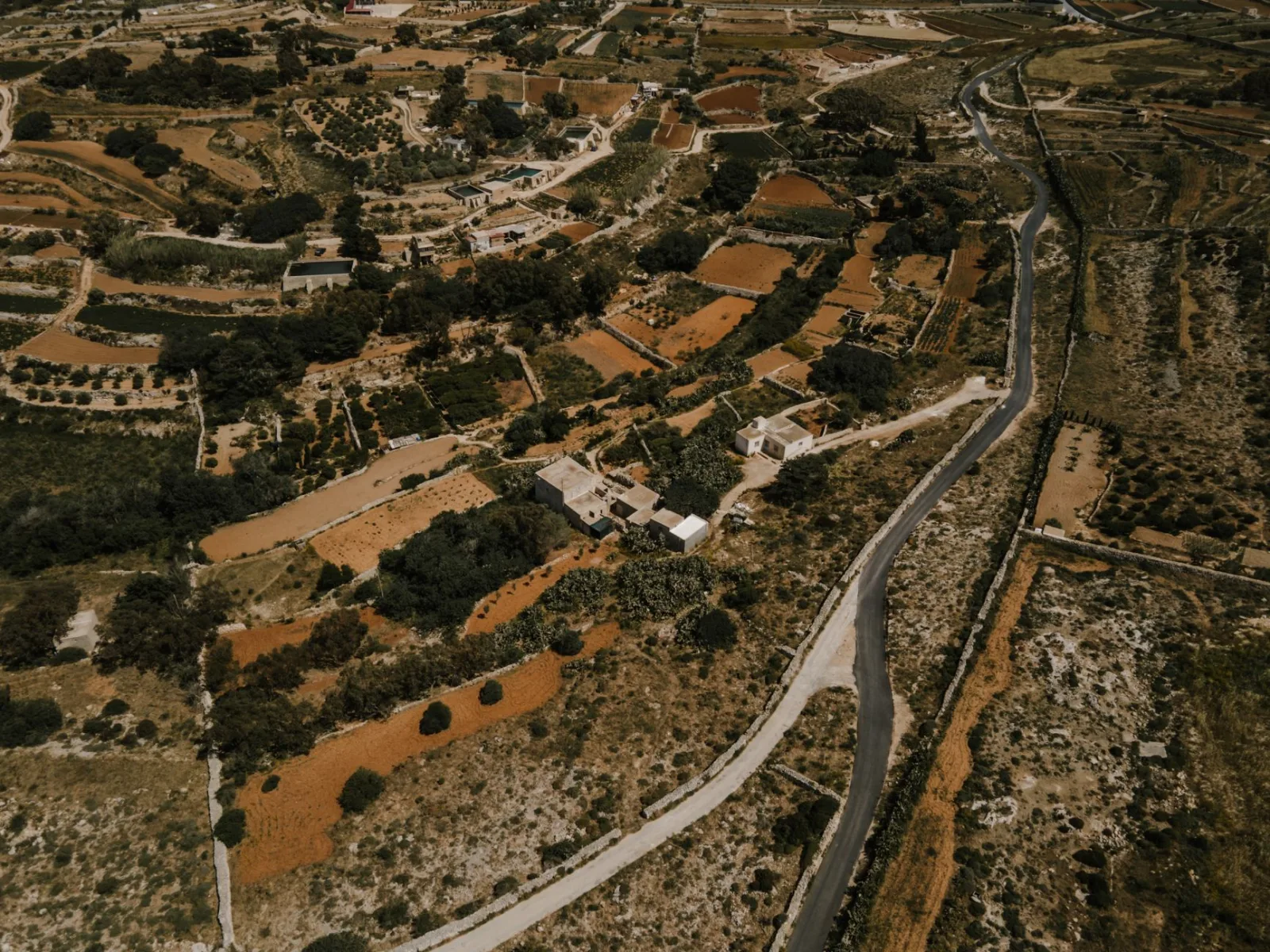 Drone view of the picturesque rural landscape in Ħad-Dingli, Malta, showcasing farms and winding roads.