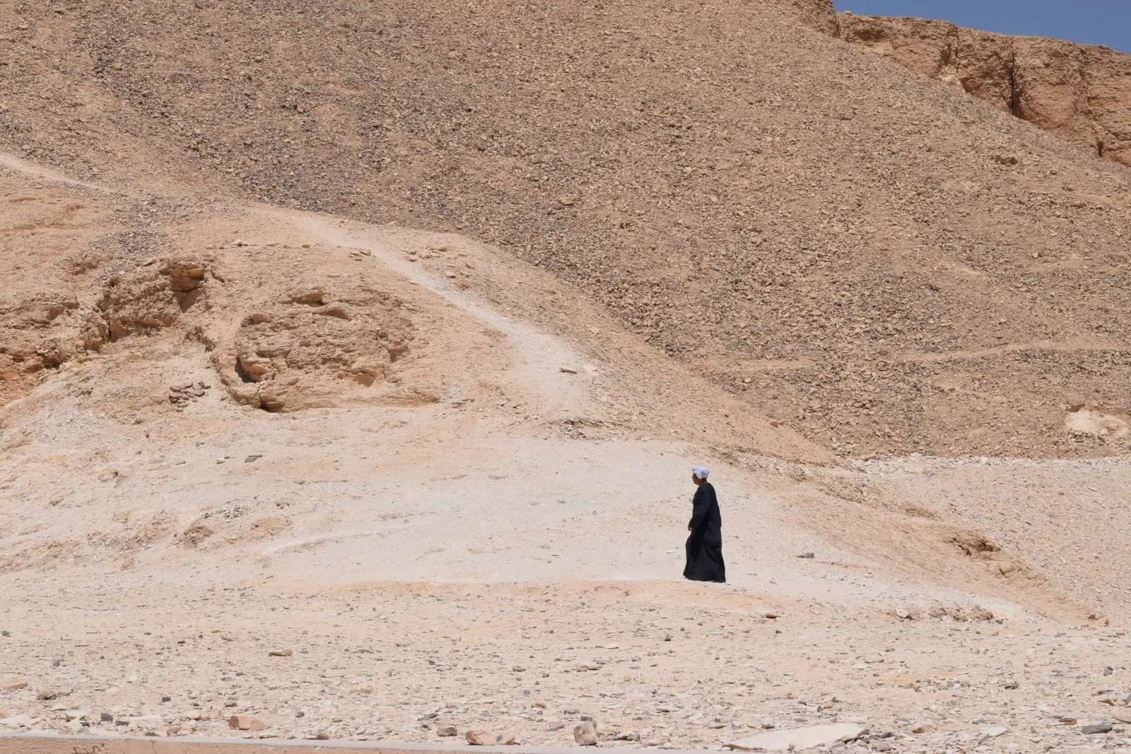 Desolate desert scene with a lone figure in Luxor, Egypt.