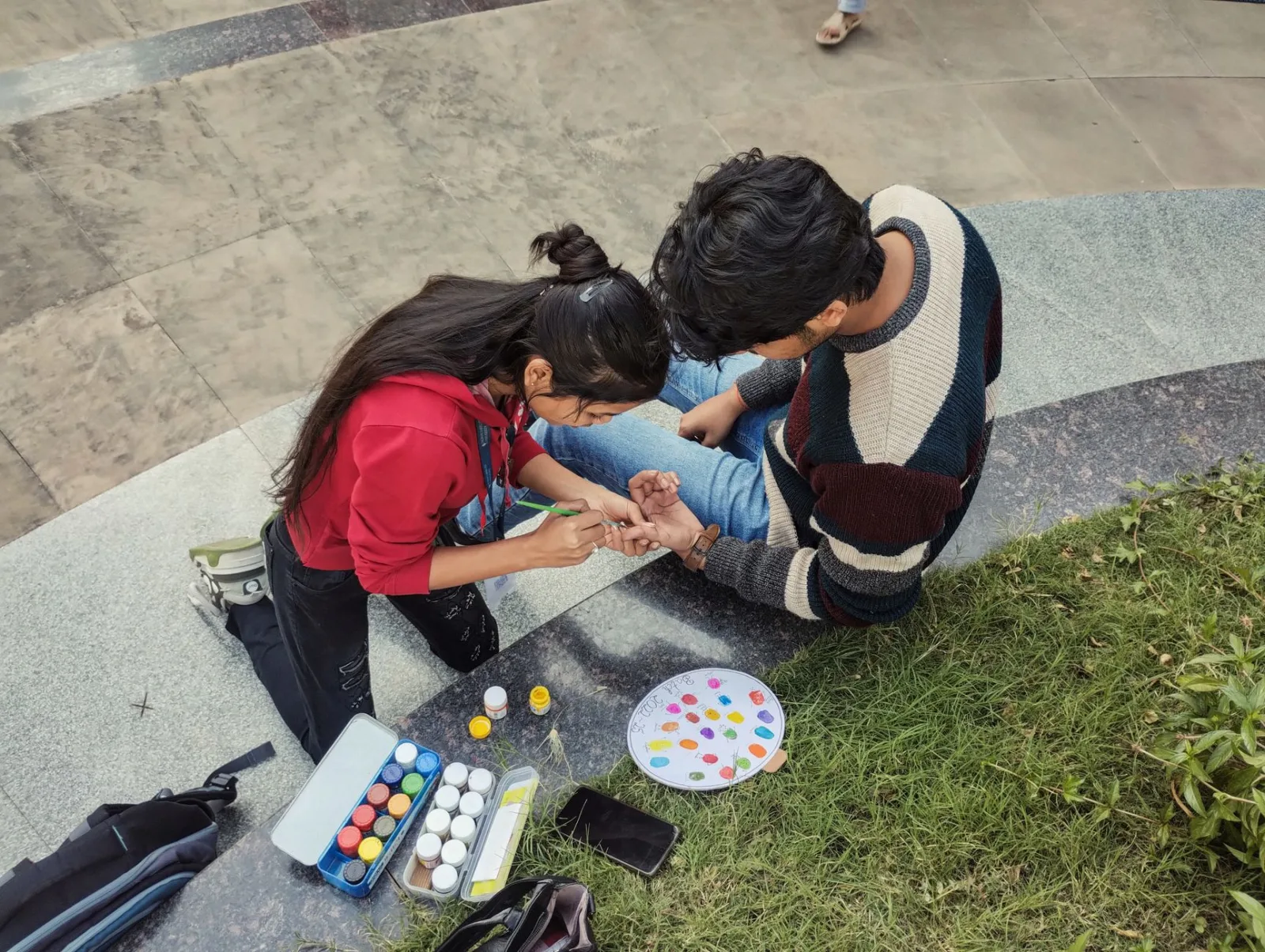Young couple engaging in a vibrant painting session outdoors. Creative and fun interaction.