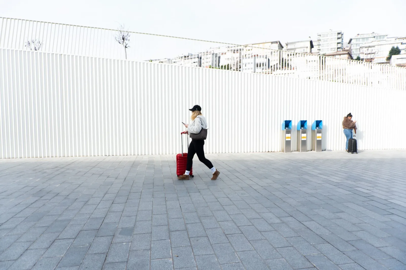 Person with suitcase walking in Kabataş, Istanbul, Türkiye, showcasing urban lifestyle and modern architecture.