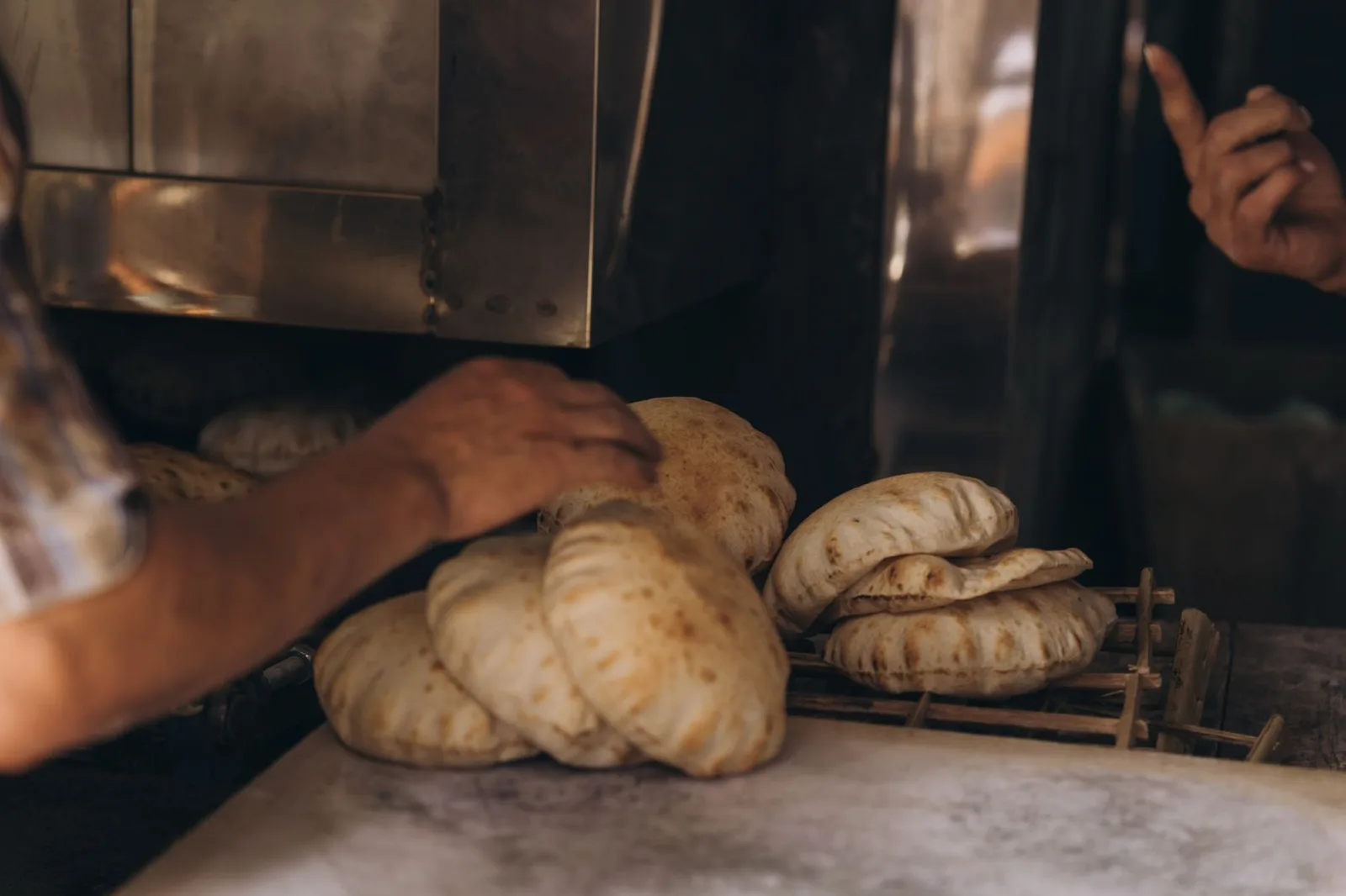 Close-up of hands baking traditional Egyptian bread in an Alexandria bakery.