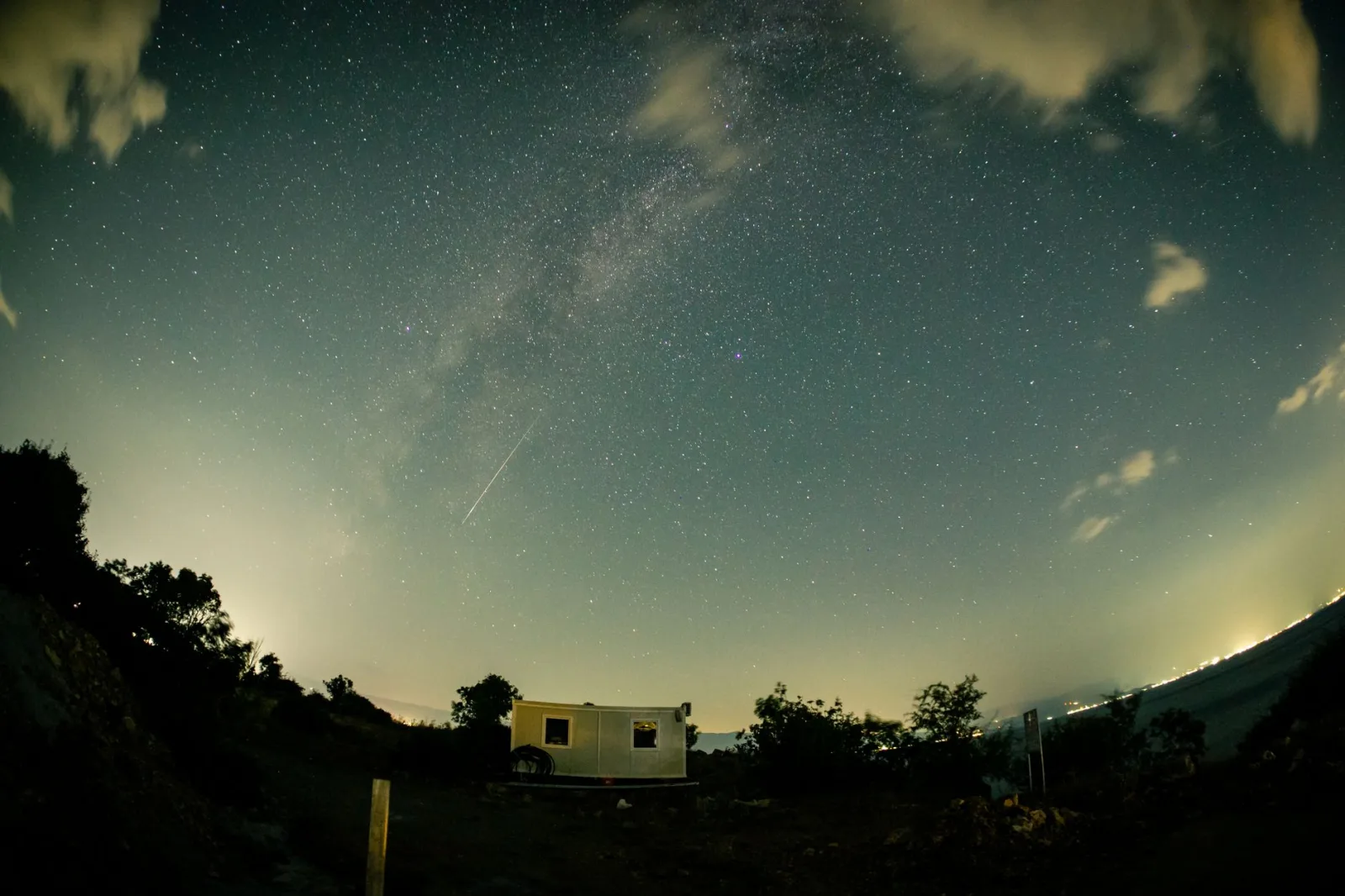 Beautiful long-exposure shot of a starry night sky with a meteor above Ohrid, North Macedonia.