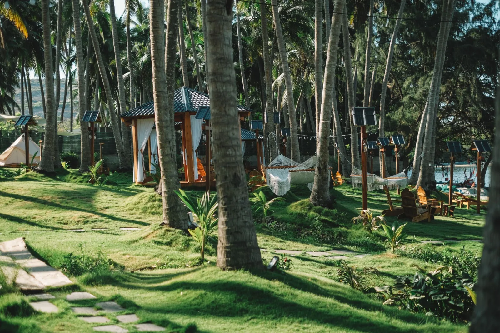 Scenic view of a lush tropical garden with hammocks in Phan Thiet, Vietnam.
