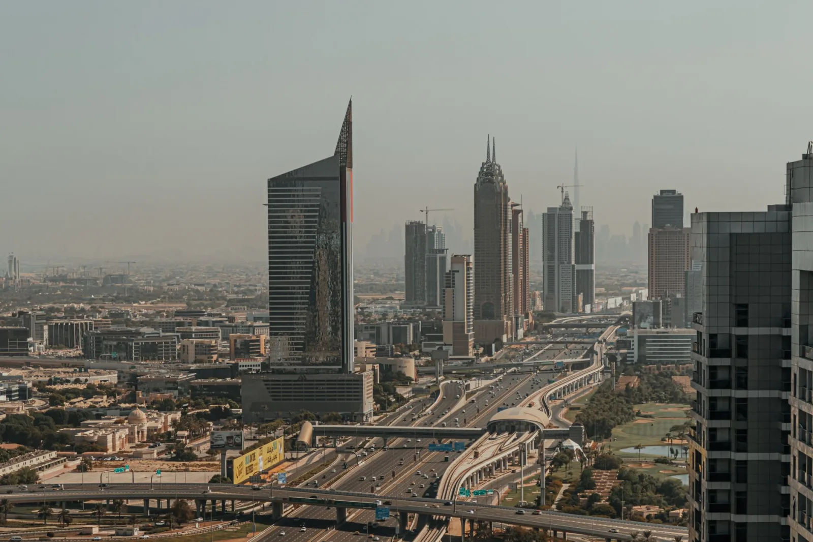 Stunning view of Dubai's skyline at dusk showcasing skyscrapers and highways in a futuristic urban landscape.