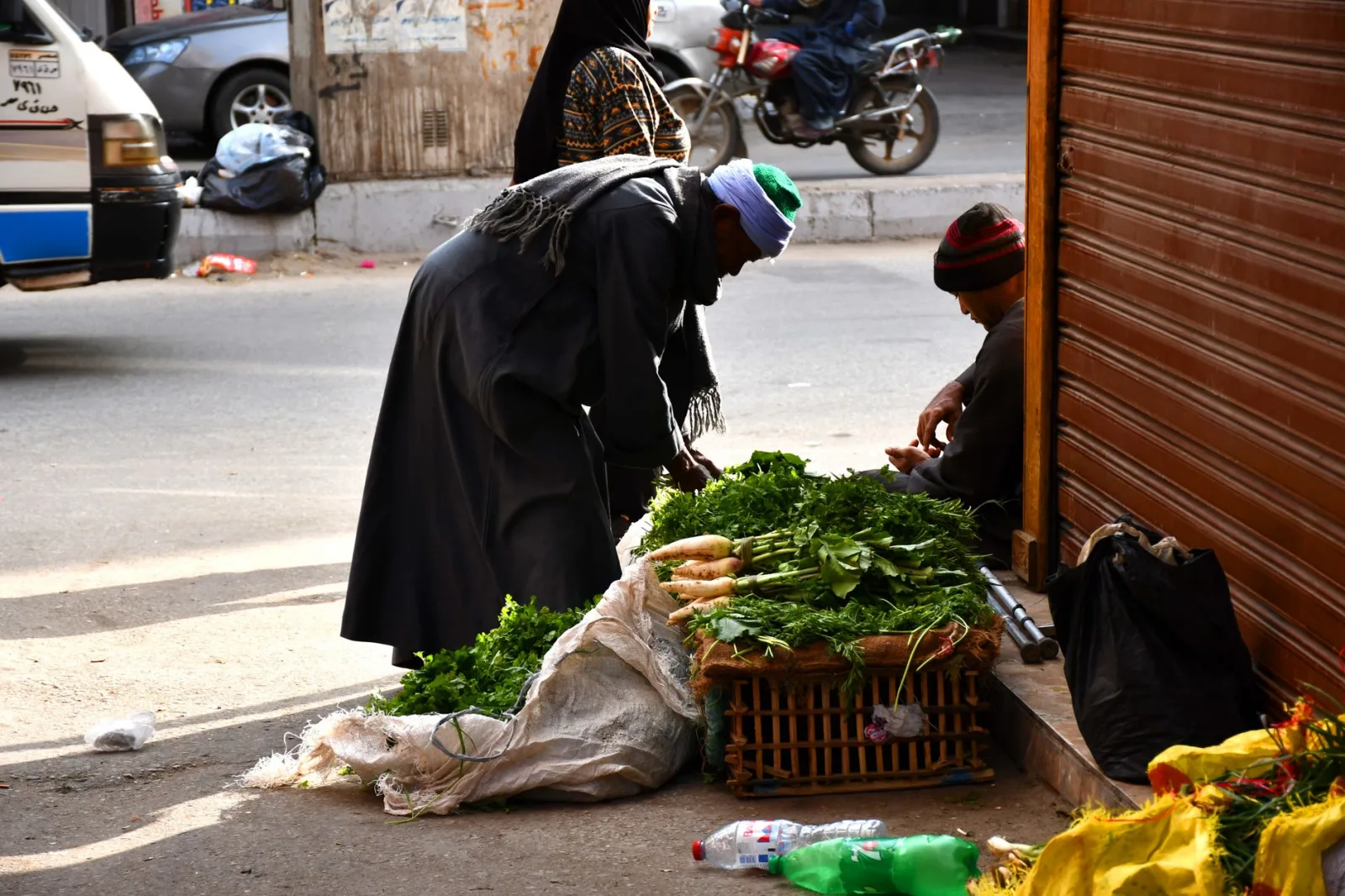 Street scene with a vendor selling fresh vegetables in Luxor, Egypt.
