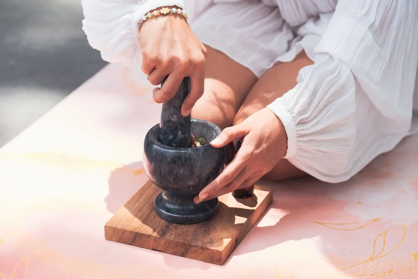 Close-up of hands using mortar and pestle for spiritual healing and meditation.