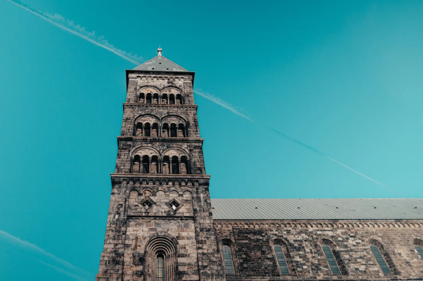 Impressive view of Lund Cathedral's tower under a clear blue sky.