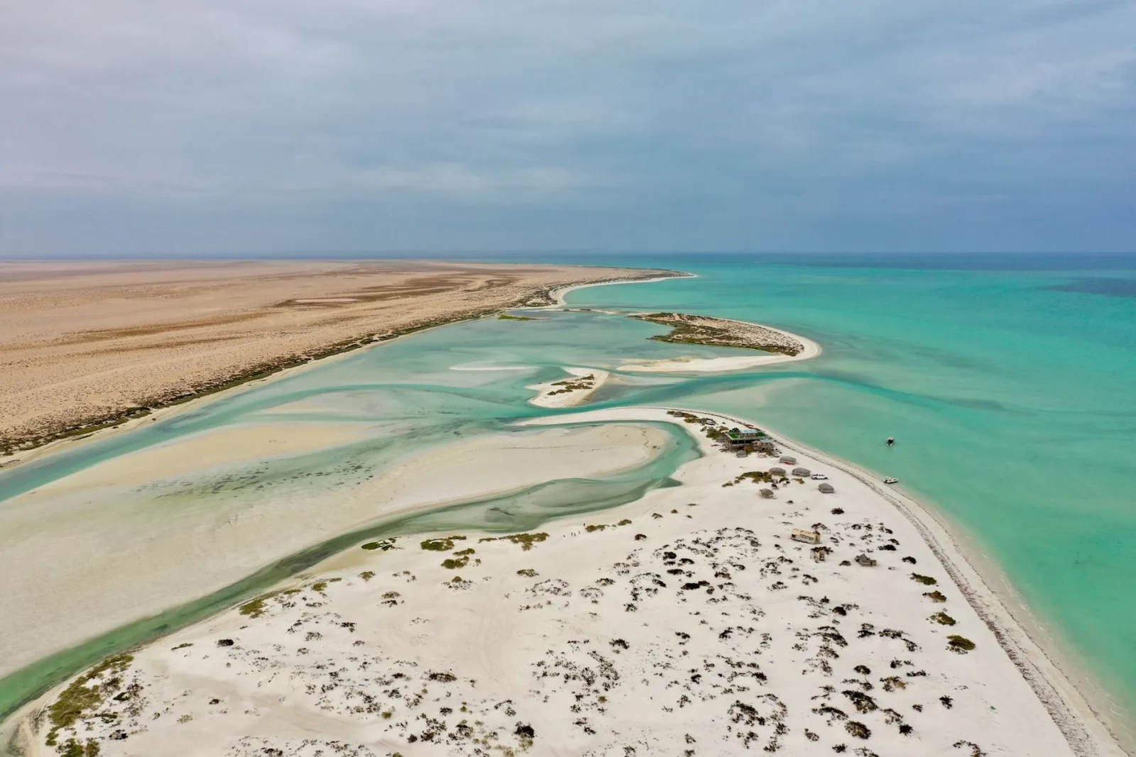 Stunning aerial view of a remote coastal landscape in Oman with turquoise waters and sandy beaches.