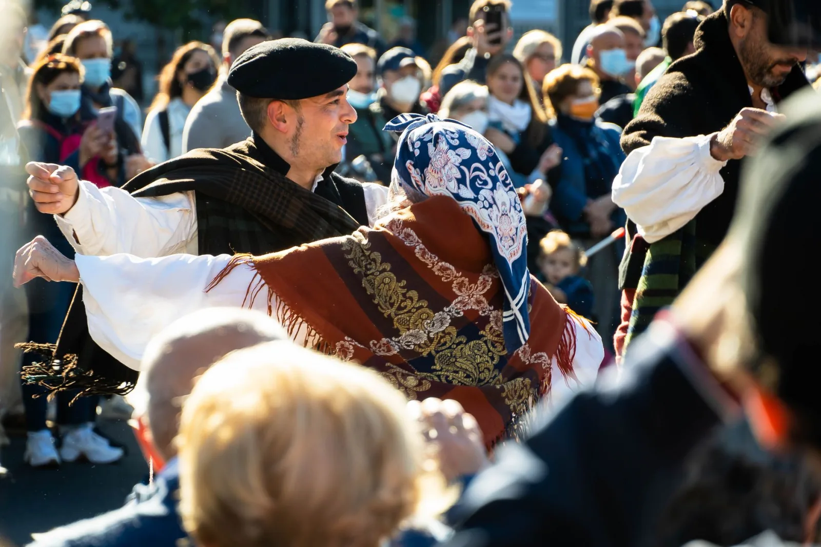 Vibrant outdoor festival with dancers in traditional attire performing during the day.