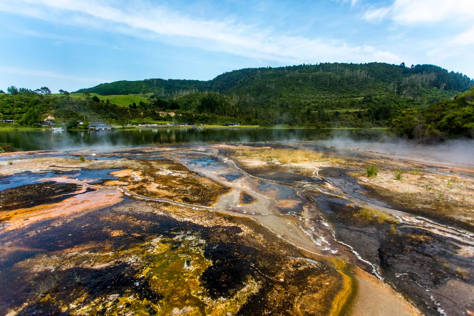 Explore the vibrant geothermal textures and scenic lake view in Taupo, New Zealand's stunning landscape.