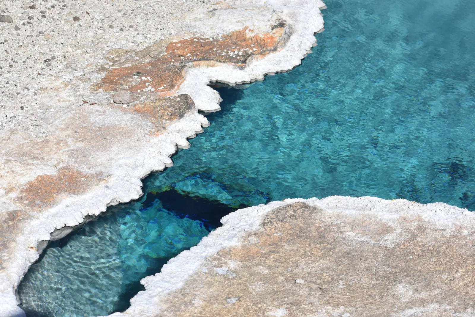 Captivating aerial shot of a vivid blue hot spring in Yellowstone National Park.