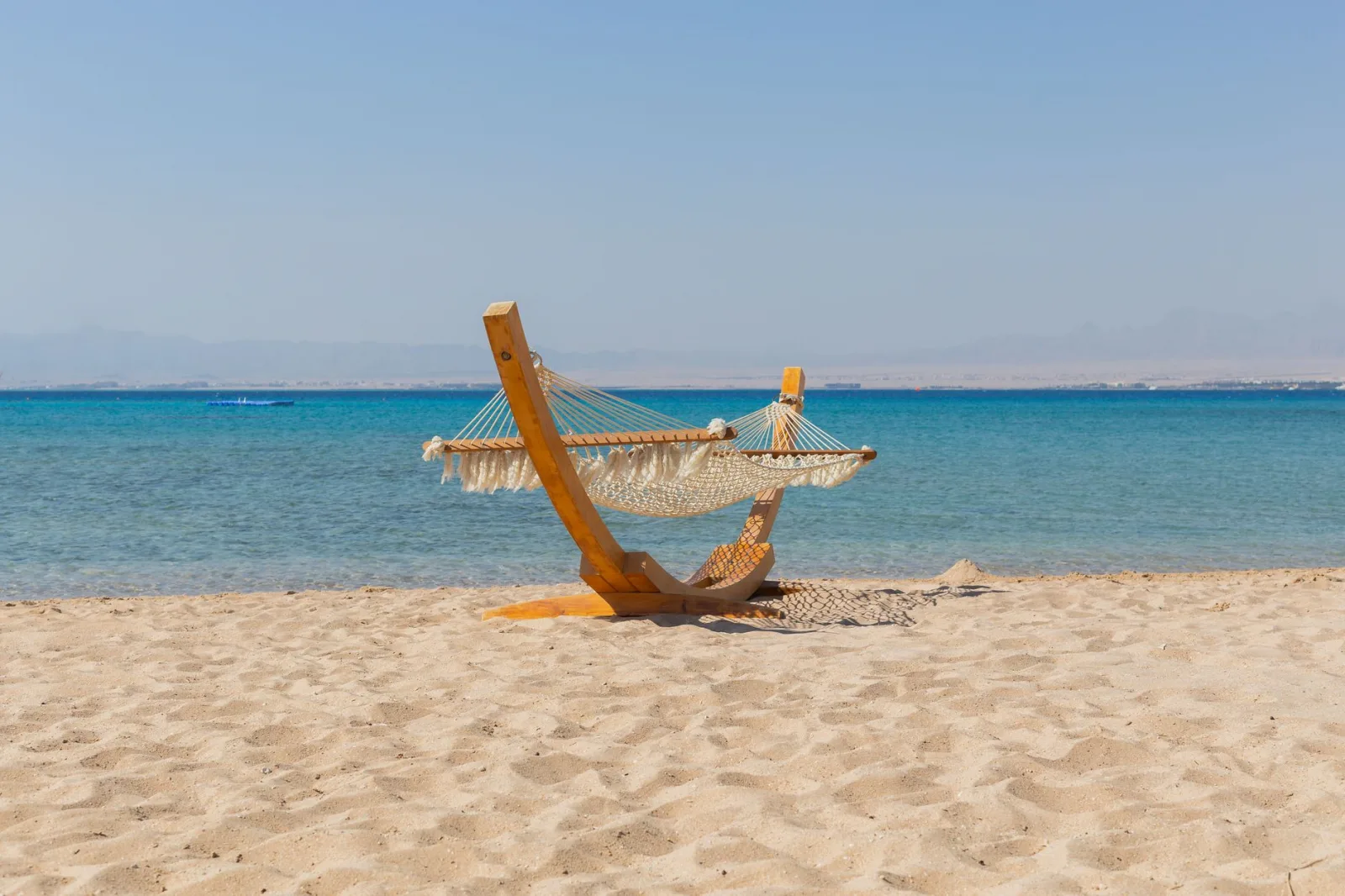 Serene beachfront hammock on the white sands of Safaga, Egypt, by the clear blue Red Sea.