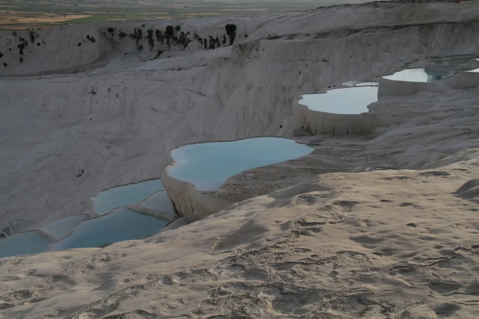 Stunning view of Pamukkale's travertine terraces and thermal pools captured at sunset.