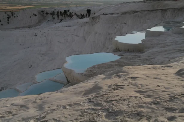 Stunning view of Pamukkale's travertine terraces and thermal pools captured at sunset.