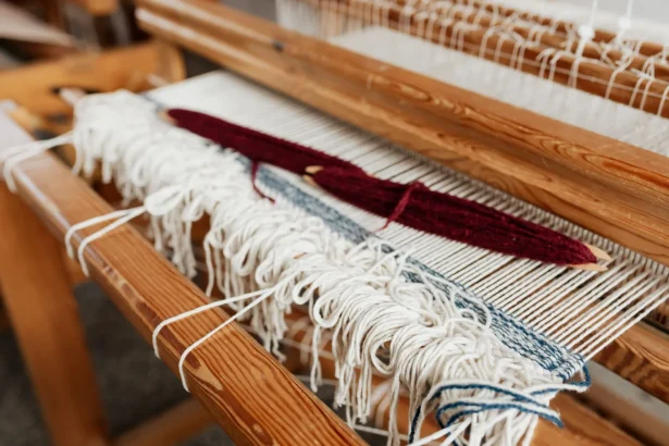 Close-up of yarn being woven on a wooden loom, showcasing traditional craftsmanship.