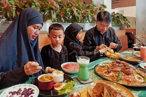 A family enjoys a meal of traditional Indonesian dishes at a restaurant in Jawa Barat.