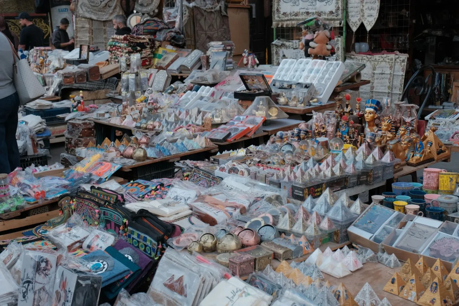 Colorful stalls with Egyptian souvenirs at a bustling market, showcasing local crafts and decor.