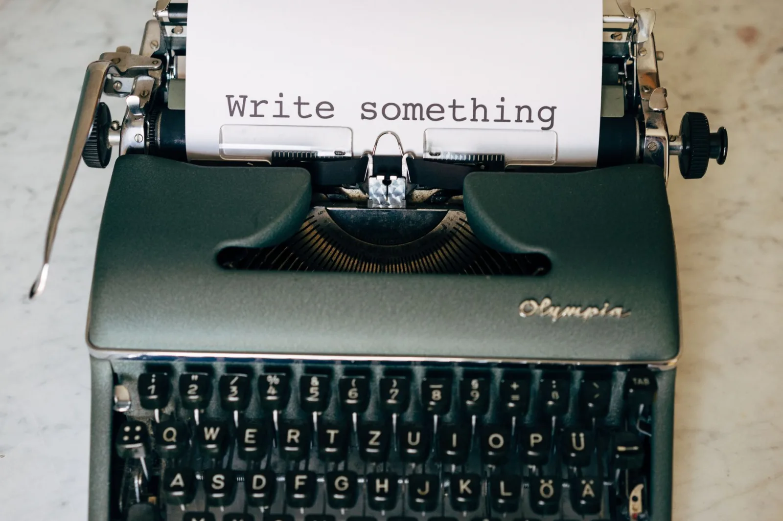 Classic typewriter displaying 'Write something' on paper. Perfect for creative inspiration.
