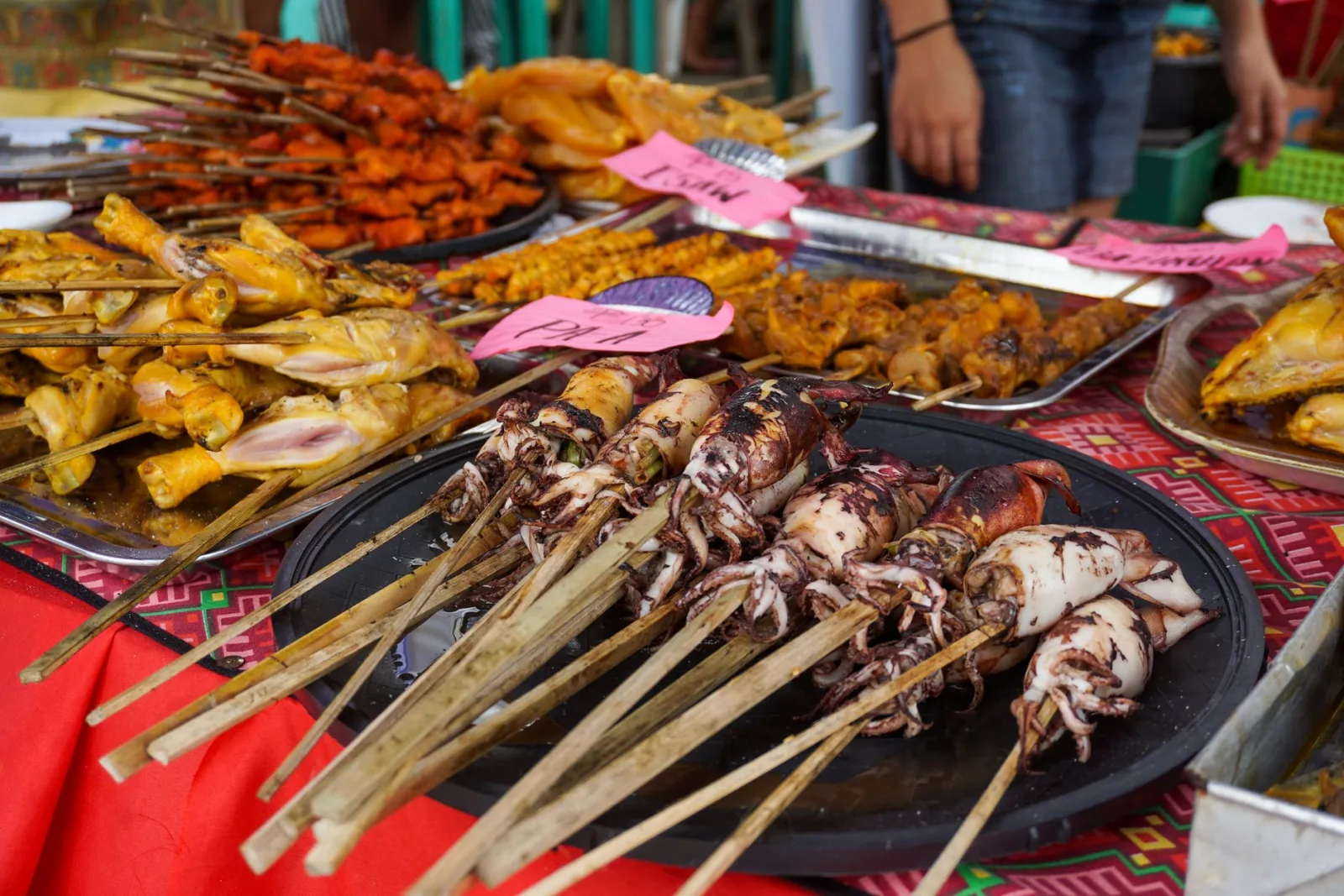 Colorful display of skewered seafood and meats at a traditional Filipino street food market in Iloilo City.