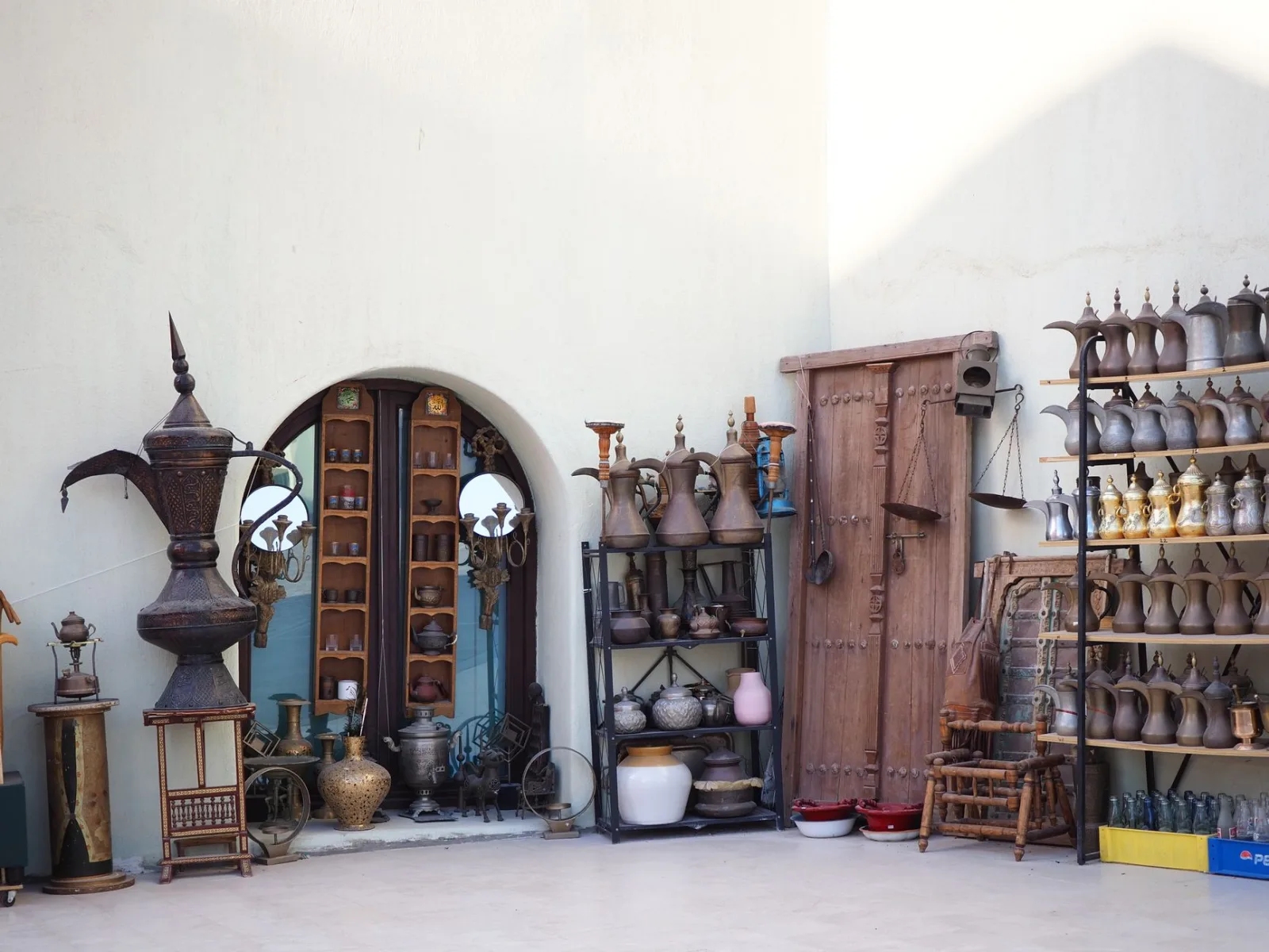 Outdoor display of traditional Arabic art and pottery at a market in Qatar.