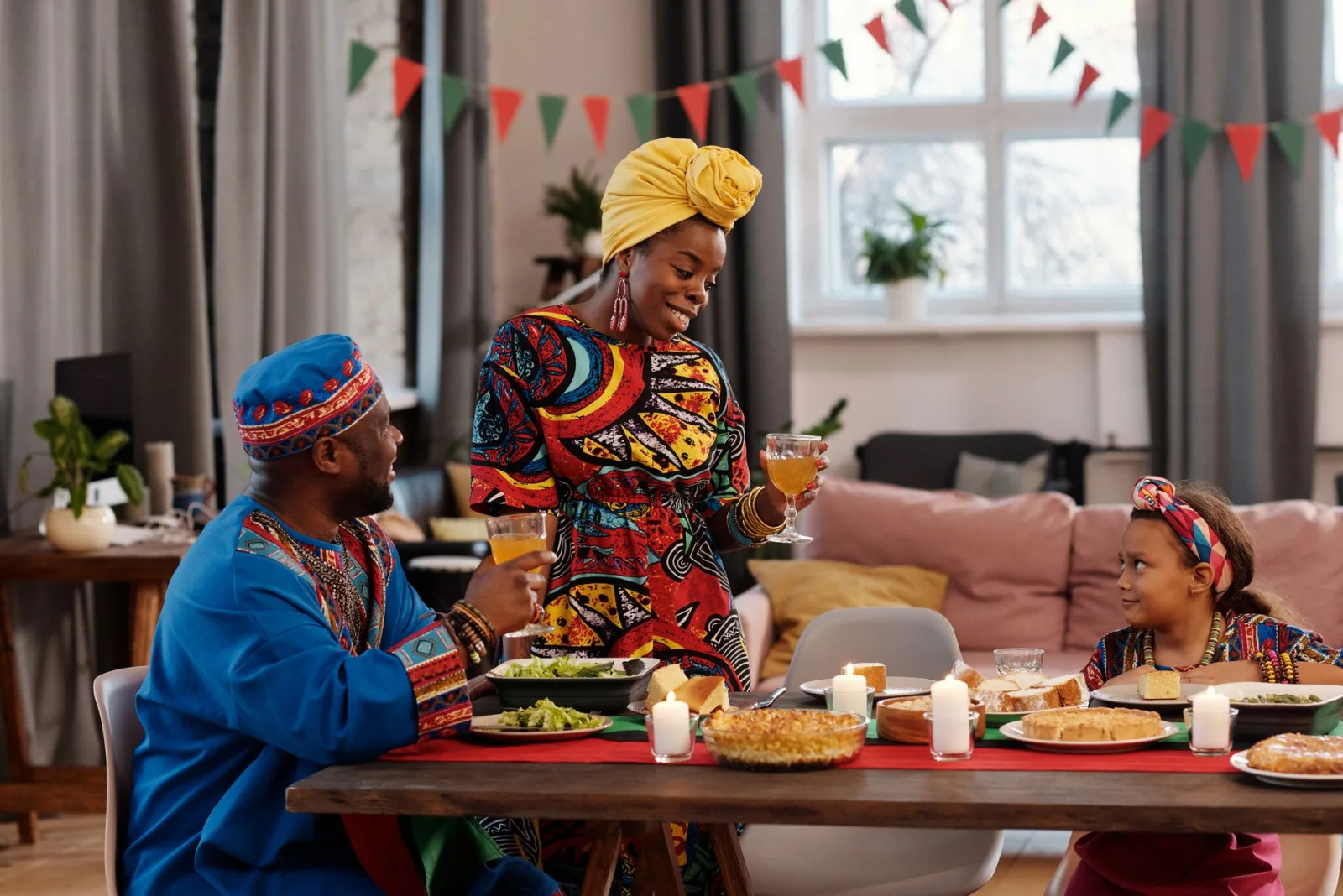 A family enjoys a festive meal in colorful traditional clothing, embracing togetherness.