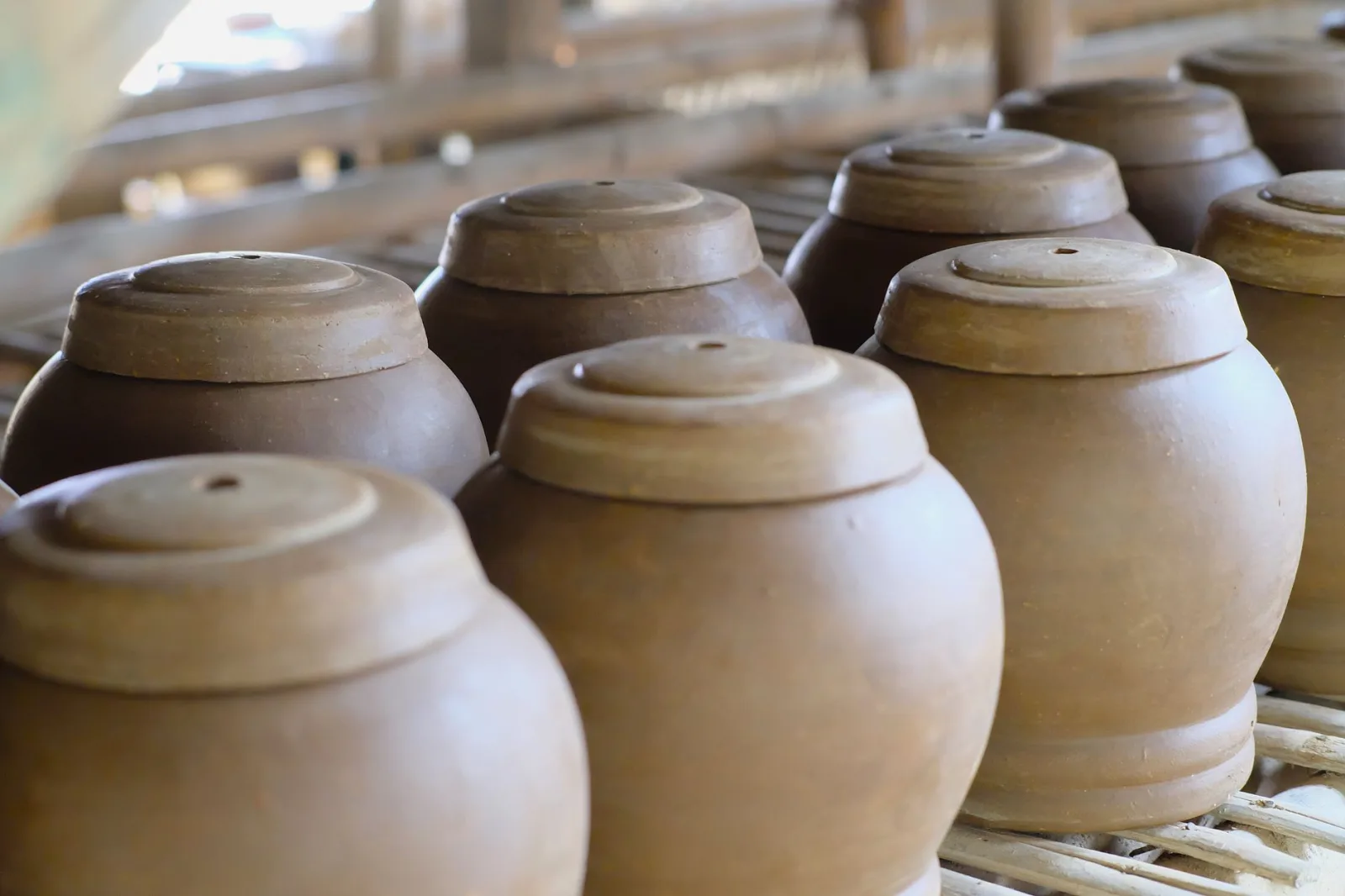 Close-up of traditional clay pots in a rustic West Java workshop setting.