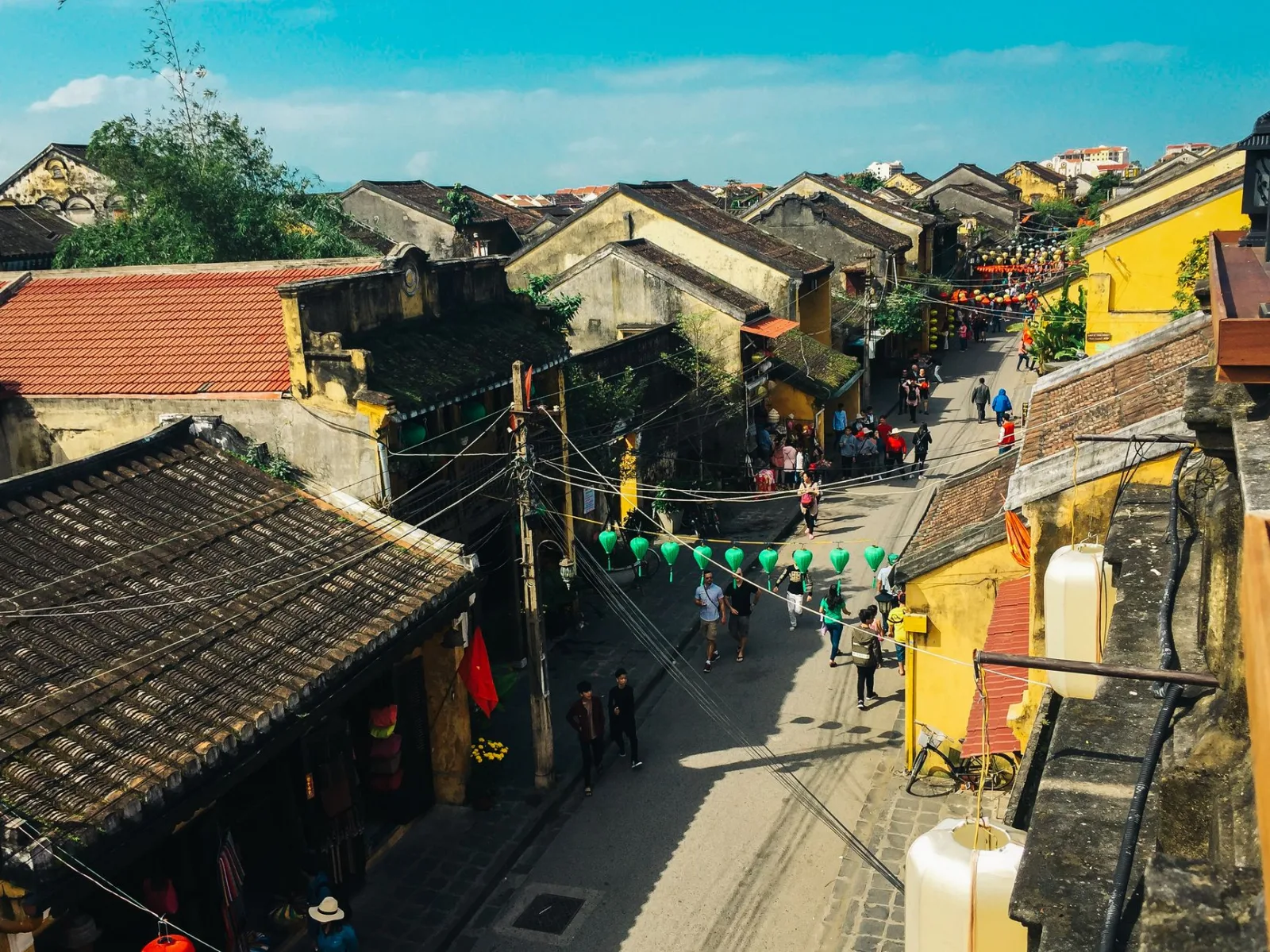 Colorful street view of a traditional town with vibrant lanterns, showcasing classic architecture and bustling street life.