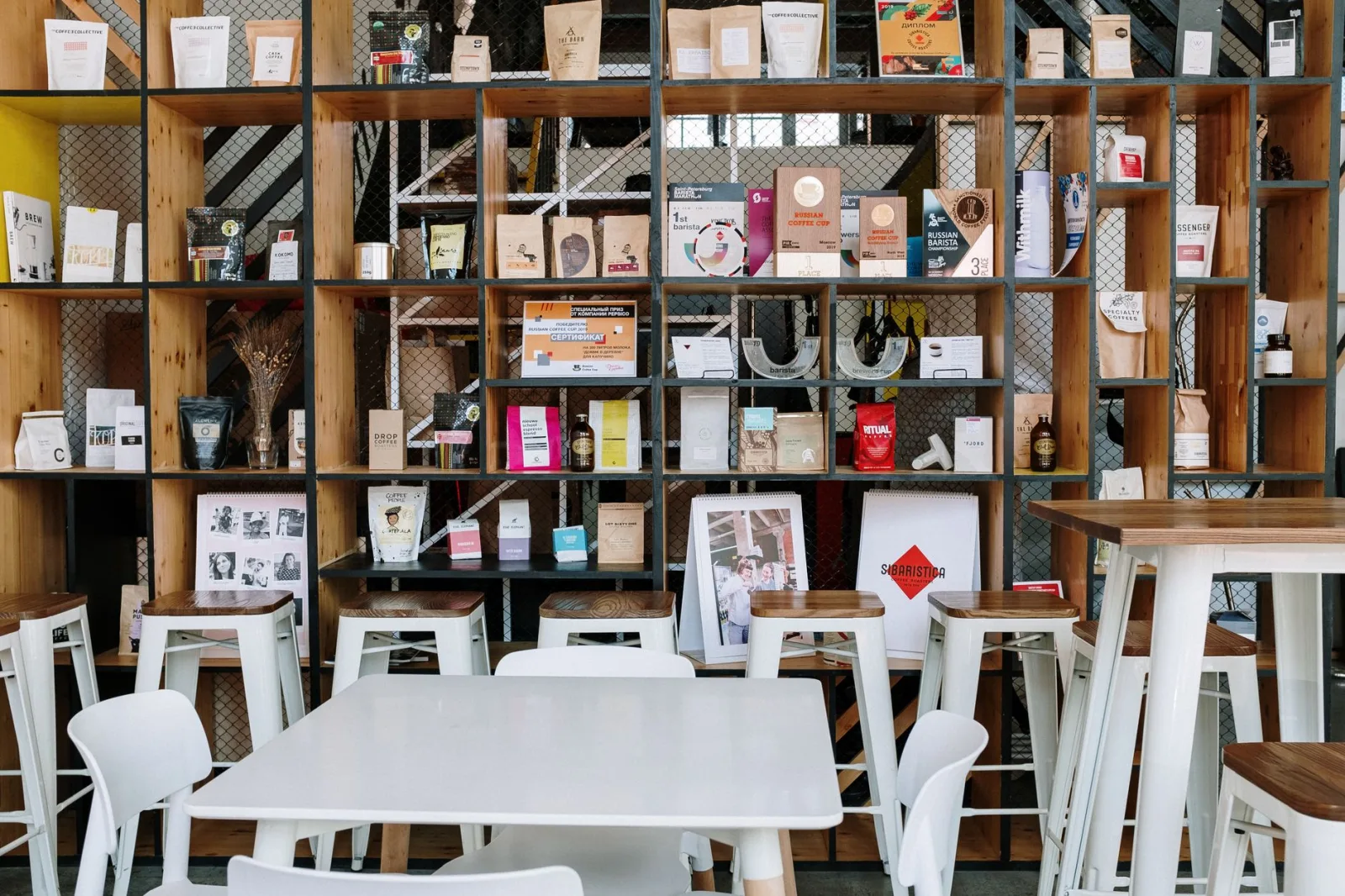 Modern café interior featuring stylish shelving with products and decor, perfect for cozy gatherings.