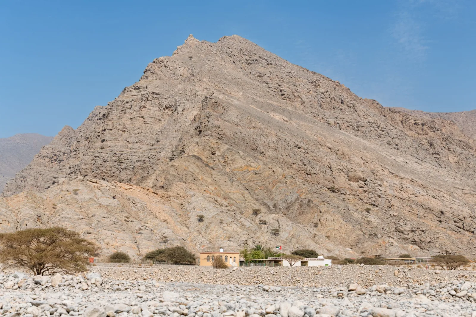 Discover the rugged beauty of Ras Al Khaimah's rocky mountain landscape under a clear blue sky.