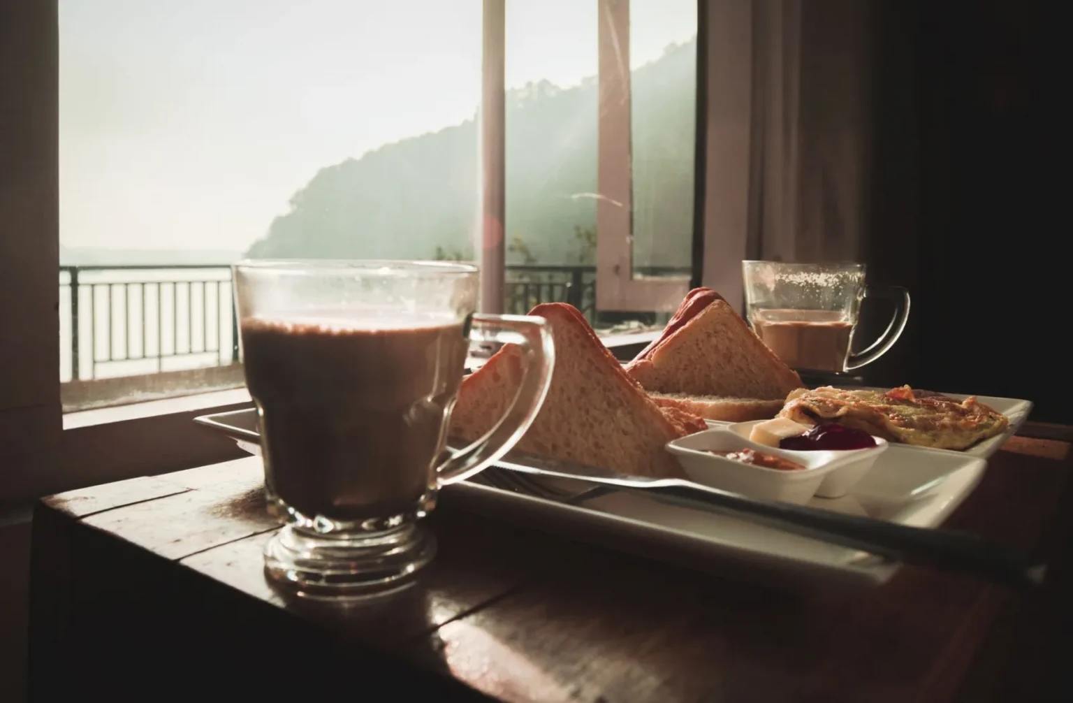 Warm breakfast with tea and toast by the window overlooking peaceful scenery in Nepal.