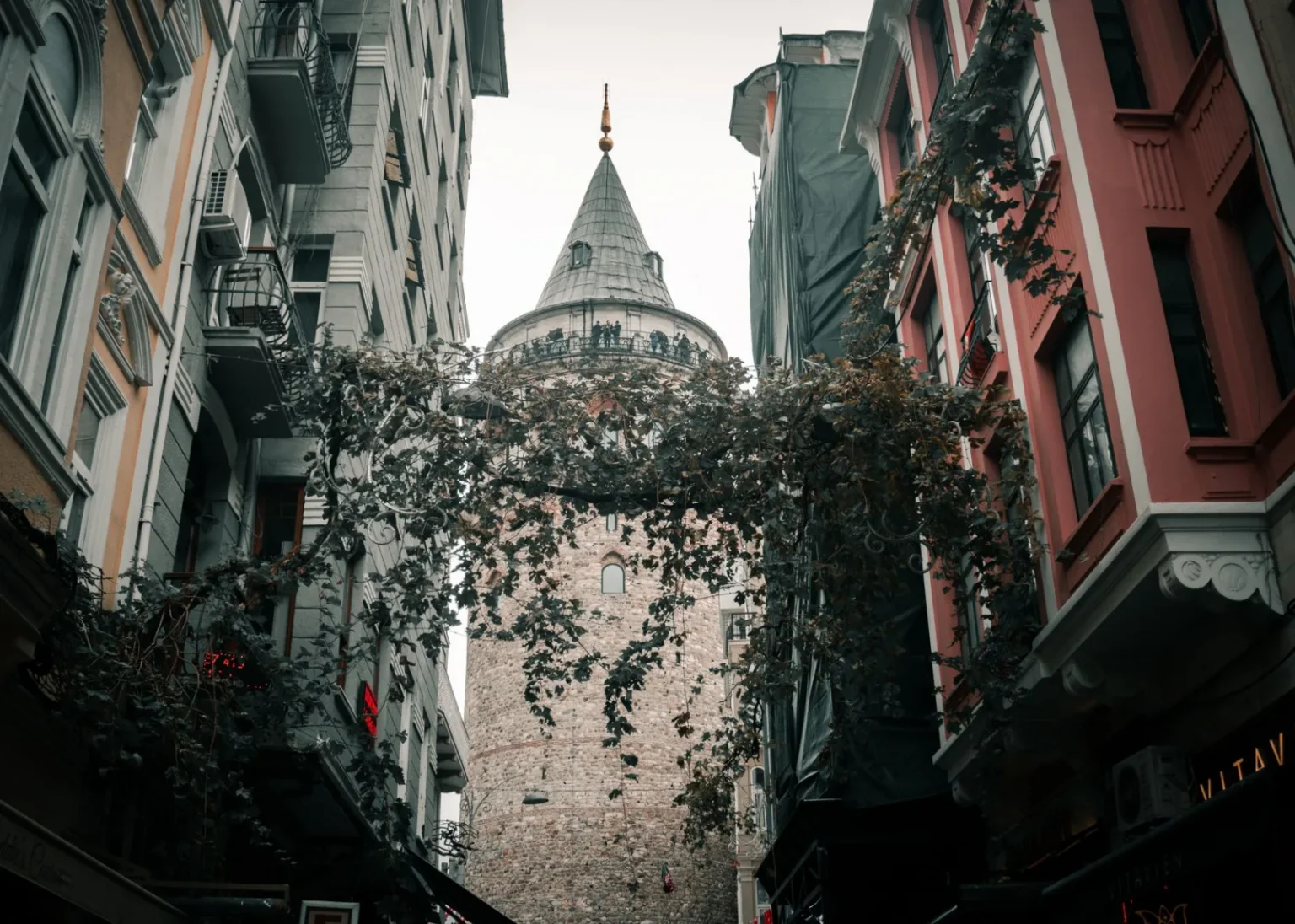View of Galata Tower nestled between historic buildings in Istanbul, Turkey.