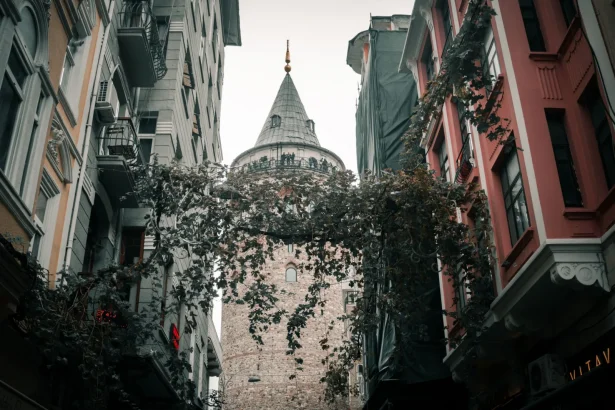 View of Galata Tower nestled between historic buildings in Istanbul, Turkey.