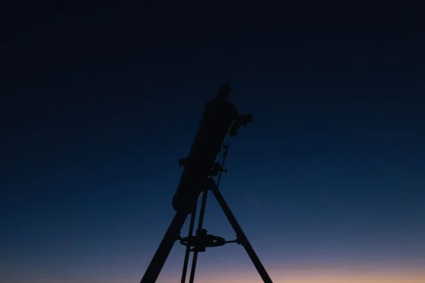 Silhouette of a telescope against a twilight sky, perfect for astronomy enthusiasts.