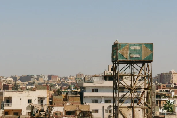 View of urban rooftops and water tower in Cairo cityscape.