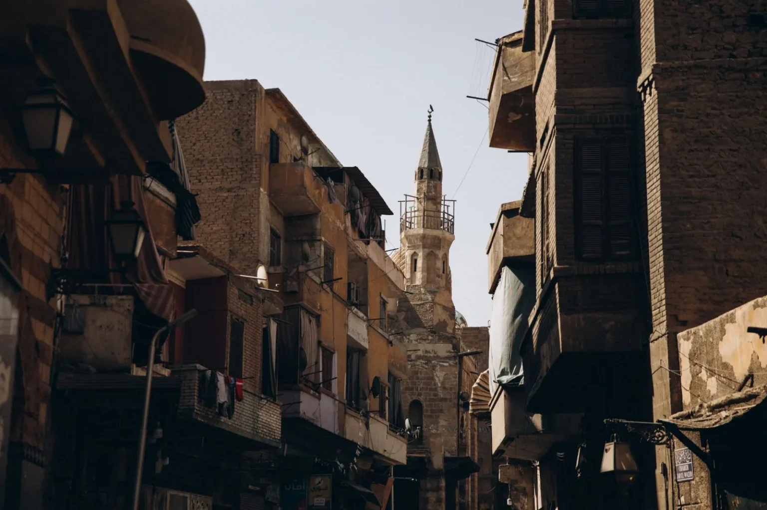 Narrow street in Cairo featuring historic Islamic architecture and urban life.